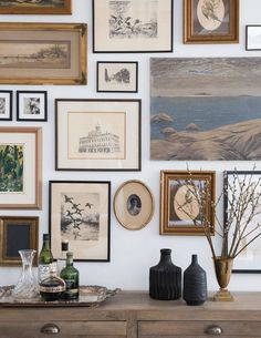 there are many framed pictures on the wall with vases and bottles next to them