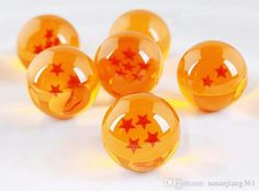 five orange balls with red stars on them sitting in the middle of a white surface