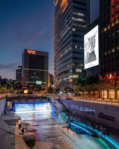 people skating on an ice rink in the city at night