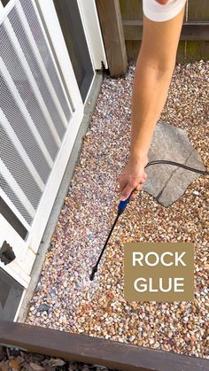 a person using a rock glue to paint the side of a house