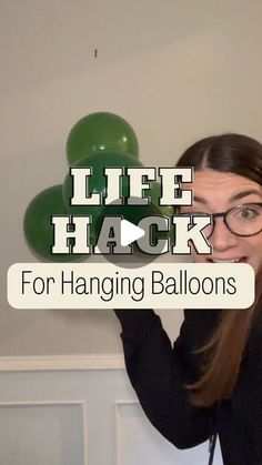 a woman holding up balloons with the words life hacky for hanging balloons above her head