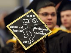 a black and yellow graduation cap with the words dou on it in front of other graduates