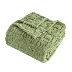 the green towel is folded up on top of it's own blanket, with an intricate design