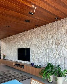 a living room filled with furniture and a flat screen tv on top of a wooden wall