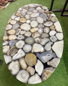 a table made out of rocks on the ground with green grass in front of it