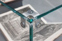 a glass table with two metal knobs on each side and a piece of paper in the background