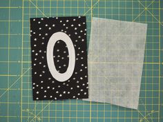 two pieces of fabric sitting next to each other on a green cutting mat with scissors