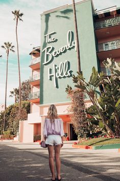 a woman walking in front of the beverly hotel