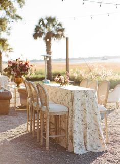 the table is set up with chairs and a cloth draped over it for an outdoor dining area