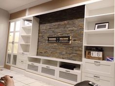 a living room with built in bookshelves and entertainment center