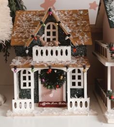 a doll house with christmas decorations on the front and side of it's roof