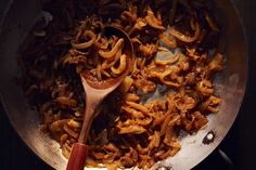 some food is cooking in a pan with a wooden spoon on the side and it looks like something out of nowhere