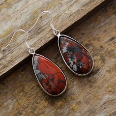 Like a small pebble hanging from the lobes of your ears, these superb dangling earrings in Natural Red Jasper will reveal their brilliant reflections. It is this specificity that makes the very beauty of this stone with such exceptional virtues. Red Jasper is known as the “supreme nurturer”. It sustains and supports through times of stress, and brings tranquility and wholeness. Jasper provides protection and absorbs negative energy. It balances yin and yang. Jasper clears electromagnetic and env Bohemian Red Gemstone Earrings, Red Teardrop Natural Stone Jewelry, Red Sterling Silver Earrings With Natural Stones, Red Jasper Jewelry With Natural Stones, Dangle Jasper Earrings With Ear Wire, Red Natural Stone Drop Earrings, Red Natural Stones Drop Earrings, Nickel-free Jasper Earrings For Gifts, Nickel-free Jasper Earrings As Gift