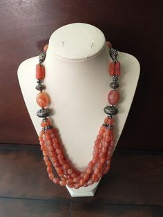 "Dramatic natural orange carnelian six strand necklace. Loads of oval beads ranging in size from 3cm to 7cm in diameter. The six strands hang from a single strand which is interspersed with fancy beads made of an unknown metal. Length is 26\" end to end, with a drape of 13\". Total weight of this piece is 302 grams! Origin and age of the necklace is unknown. May be Tibetan, Indian, ...? Thank you for shopping at The Looking Glass Plus!" Orange Carnelian, Fancy Beads, Oval Beads, How To Make Beads