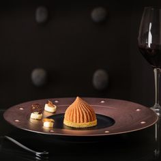 a dessert on a plate next to a glass of wine