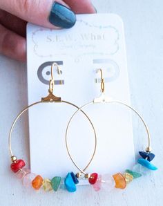 Rainbow gemstone hoop earrings. This combination of gemstones displays the beautiful colors of the rainbow. Stays secure with our flower rubber backings. Each earring is uniquely made with love and durable for everyday wear.Stones: Red Coral Bamboo, Rose Quartz, Quartz, Citrine, Ametrine, Aquamarine, TurquoiseLength: Approx. 2inMaterials: 40mm nickel-free plated brass hoops, 925 sterling silver/925 14k gold plated sterling silver earringwires, 3mm gold/silver zinc alloy (lead-free) beads 10% OF Beach Style Jewelry, Hoop Earrings Diy, Bead Hoop Earrings, Beaded Chandelier Earrings, Gemstone Hoop Earrings, Colors Of The Rainbow, Rainbow Gemstones, Wire Jewelry Designs, Chakra Jewelry