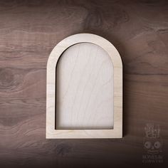 a wooden arch with a hole in the middle on a wood background that looks like it has been made out of plywood