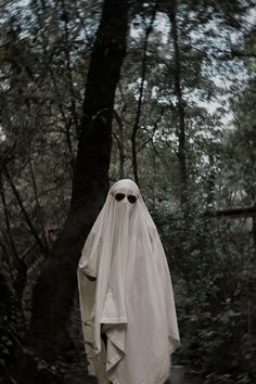 a ghostly figure is standing in the woods