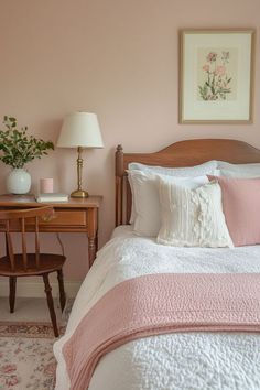 a bedroom with pink walls and white bedding, two nightstands and a desk