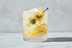 a glass filled with lemon and limeade on top of a table next to a wall