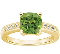 a green cushion cut ring with diamonds on the band