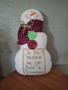 a snowman with a button on it's head and saying in the meadow we can build a snowman