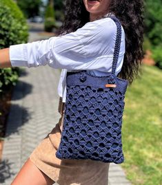 a woman carrying a blue crocheted purse