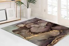 an area rug that looks like it is made out of marble and gold leafy designs