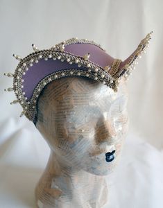 This beautiful renaissance attifet headdress is covered with lilac taffeta and embellished with beige trimming all around the edges.The headpiece is further trimmed with with elegant pearl bead details all around. The headpiece is very light and comfortably stays in place with an adjustable elastic that goes under the hair and at the back of the neck. You can adjust the strap to be as tight as you want. For a complete look this headpiece may be combined with this collar: https://www.etsy.com/lis Elizabethan Ruff, Elizabethan Collar, Mardi Gras Costumes, Wedding Headdress, Tudor Style, Costume Hats, Historical Costume, Mad Hatter, Headdress