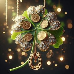 a four leaf clover ornament hanging from a string with coins and horseshoes attached to it