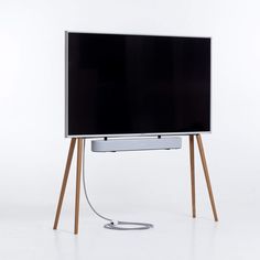 a flat screen tv sitting on top of a wooden stand next to a white wall