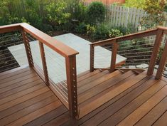 a wooden deck with metal railing and handrail