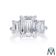 an emerald cut diamond ring with three baguetts in the center and side stones