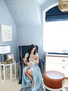 a woman sitting in a chair holding a baby