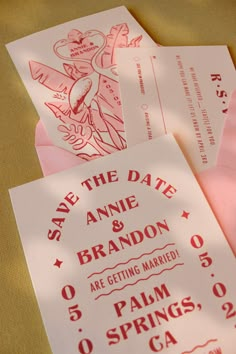 pink and white wedding save the date cards with matching envelopes are on a table