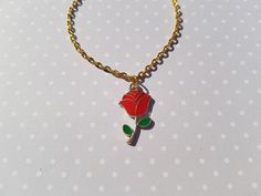 "this classy red rose bracelet would be a lovely gift for someone special! this delicate charm bracelet is made using a gold plated enamel pendant hung from gold plated chain.  total length of chain measures approx. 7\" and fastens with a lobster clasp fastener.  rose charm measures approx. 23mm x 13mm" Gold Flower Bracelets With Rose Design, Gold Floral Bracelets With Rose Design, Gold Flower Bracelet With Rose Design, Rose Gold Flower Charm Bracelet As Gift, Rose Colored Bracelets For Valentine's Day Gift, Rose Gold Bracelet With Rose Design For Gift, Gold Bracelet With Rose Design For Gift, Valentine's Day Gift Bracelet With Rose Design, Rose Jewellery