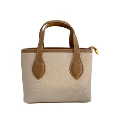 "Introducing the Harper mini leather tote bag in cream, designed by Laurenti New York. This compact and stylish bag is perfect for carrying all your essentials, from brunch to a night on the town. Crafted from high-quality leather, the Harper mini tote features a cream exterior that is both chic and versatile. The interior is lined with durable fabric and features ample space for storing your phone, wallet, keys, and other small items. The comfortable shoulder strap allows for easy, hands-free wear, while the gold-tone hardware adds an extra touch of elegance to this already stunning bag. Whether you're heading out for a casual brunch with friends or a fancy evening out, the Harper mini leather tote bag is the perfect accessory to complete any outfit. With its sleek and versatile design, y Mini Tote, Phone Wallet, Stylish Bag, Leather Tote Bag, Small Items, High Quality Leather, Hands Free, Leather Tote, Mini Bag