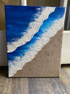 an acrylic painting of waves on the beach in blue, white and gray