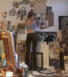 a woman is standing in an art studio