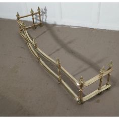 a gold metal bed frame sitting on top of a floor