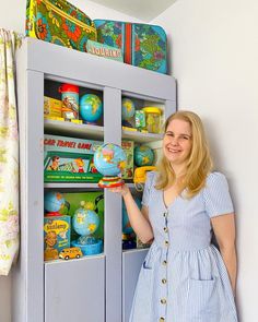 a woman is standing in front of a toy cabinet