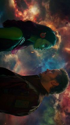 a man standing next to a woman in front of a galaxy background