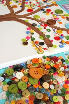 there are many buttons on the table and one has a tree with leaves in it