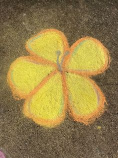 an orange flower drawn in chalk on the ground