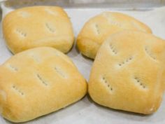 four pieces of bread sitting on top of a piece of wax paper in a pan