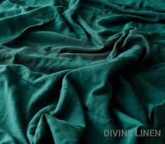 an image of a bed that is made with teal colored sheets and linens