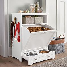 an open white cabinet with two bowls and utensils in it