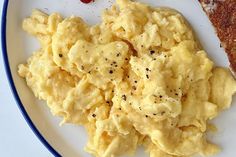 scrambled eggs on a white plate with toast