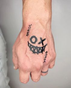 a person's hand with a smiley face tattooed on the left side of his arm