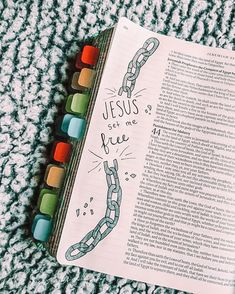 an open bible with the word jesus got me free written on it and colored crayons